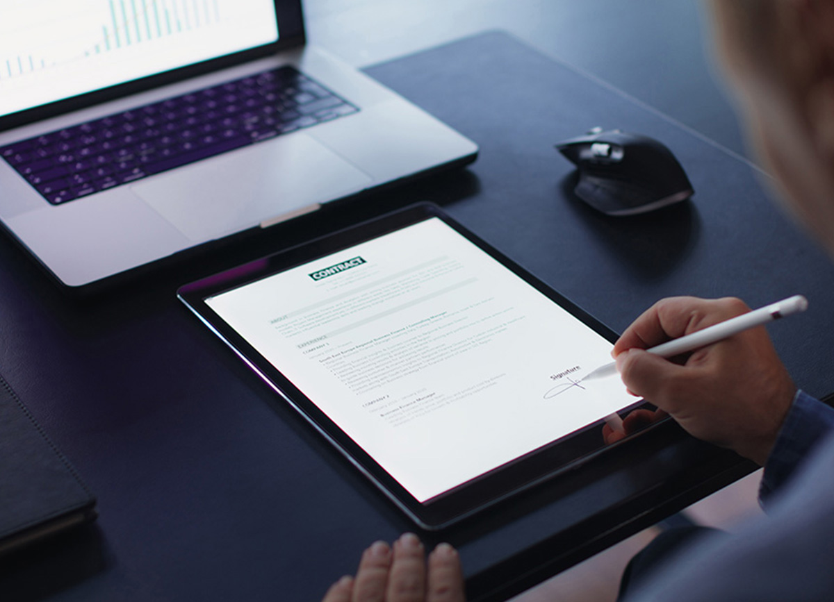 Person unterschreibt ein Dokument digital auf einem Tablet