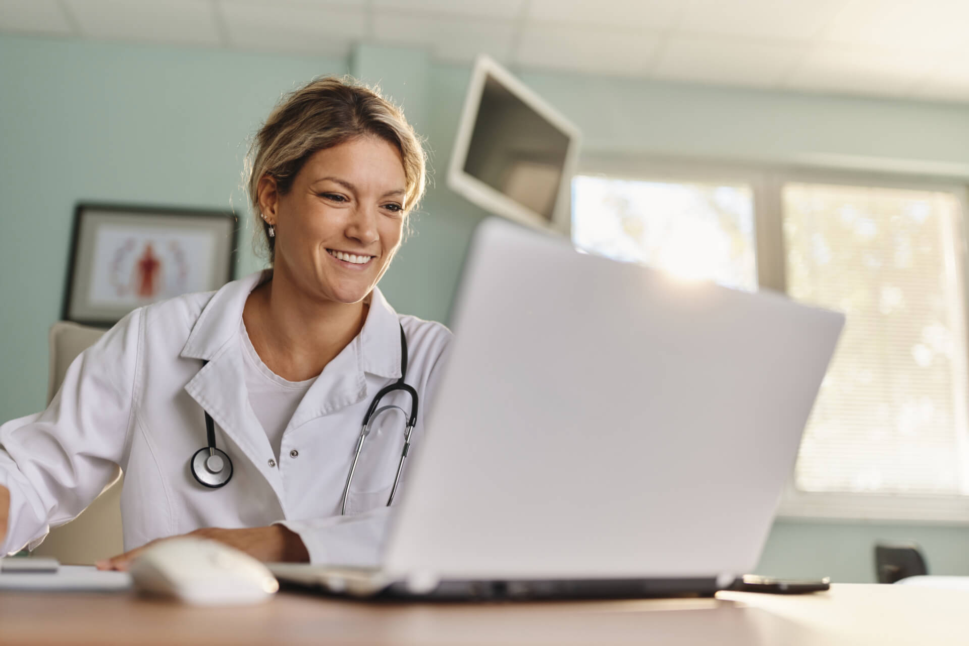 Doctor smiles at laptop
