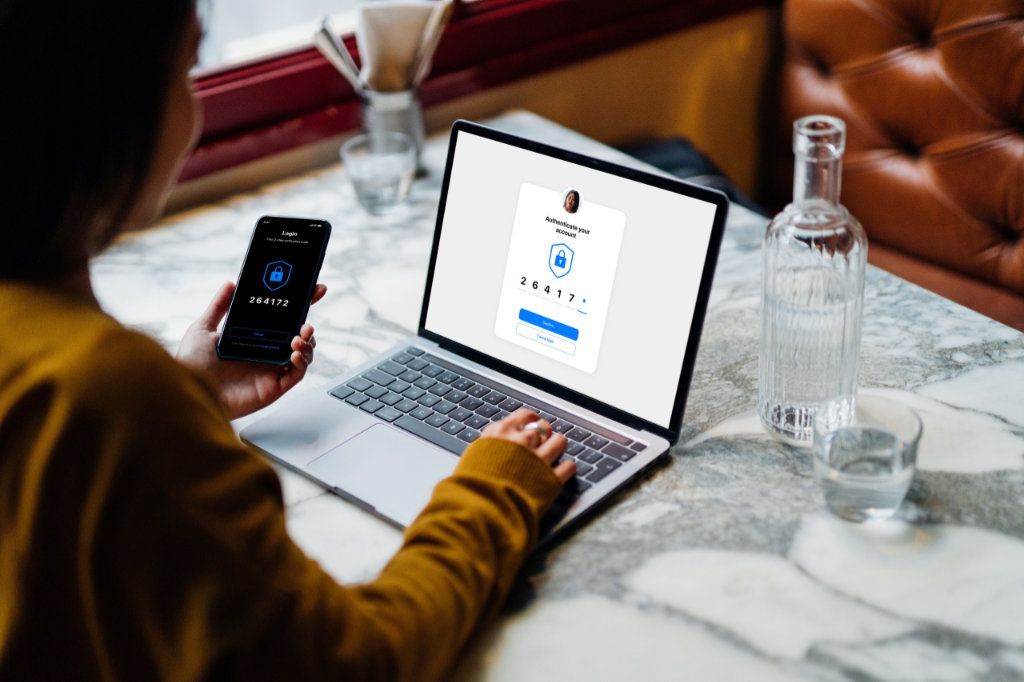 Frau sitzt mit Smartphone und Tablet am Tisch Frau Smartphone Tablet Tisch