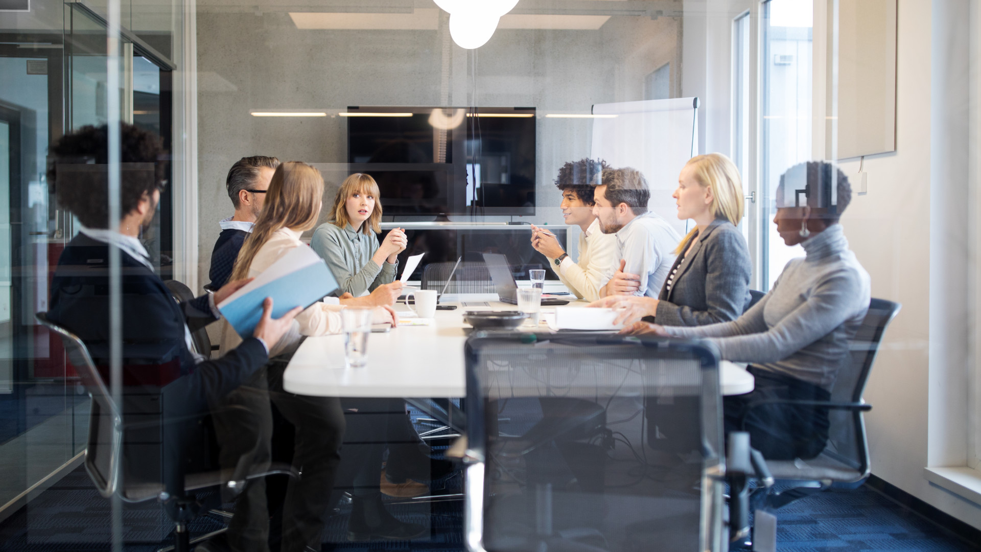 Personen sitzen an einem Konferenztisch Personen sitzen an einem Konferenztisch