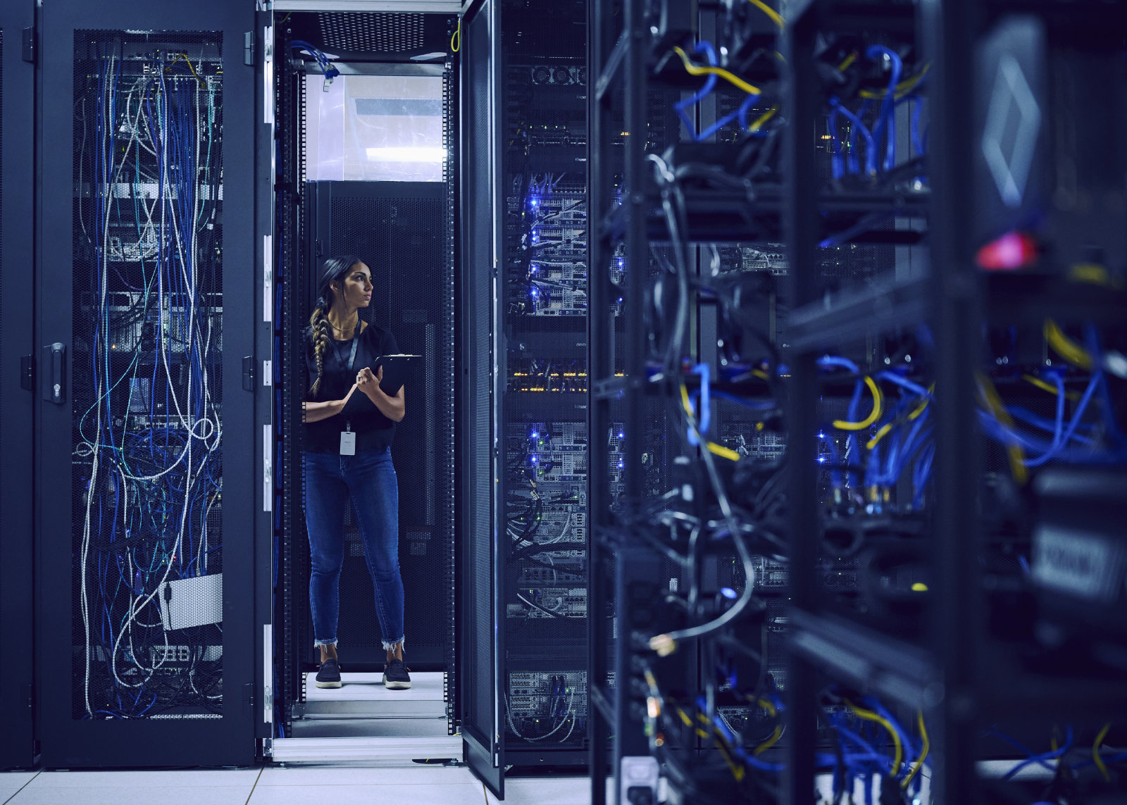 Frau mit Klemmbrett in Serverraum Frau mit Klemmbrett in einem Serverraum
