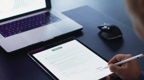 Person unterschreibt ein Dokument digital auf einem Tablet