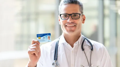 Doctor holds doctor's ID card up to the camera