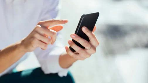 Eine Frau hält ihr Smartphone in den Händen Eine Frau hält ihr Smartphone in den Händen