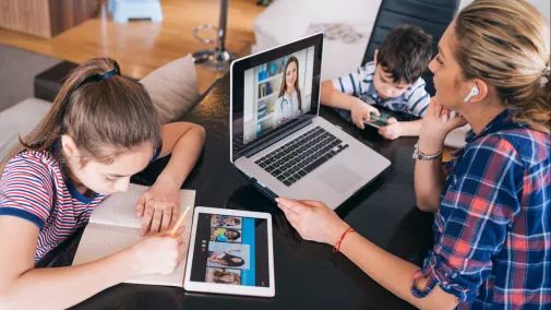 women working on tablet sitting with chid at home 