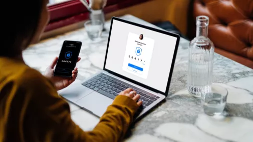 Frau sitzt mit Smartphone und Tablet am Tisch Frau Smartphone Tablet Tisch