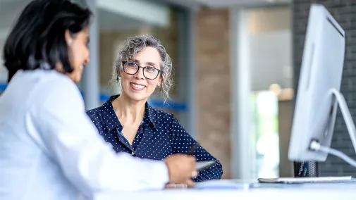 Zwei Frauen sitzen vor einem Computer. Zwei Frauen sitzen vor einem Computer.
