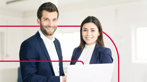 Business man and woman side by side in front of a laptop