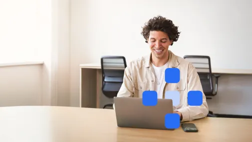 A man works on his laptop and smiles.