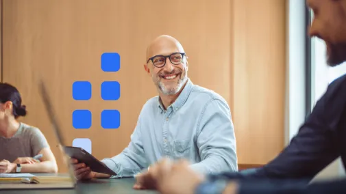 A man holds an iPad in his hand and smiles