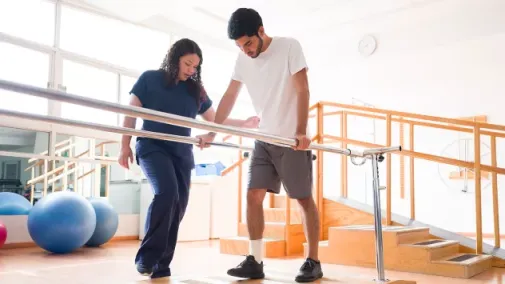 Foto eine Physiotherapeutin, die einen männlichen Patienten in einer Physiotherapie-Praxis behandelt