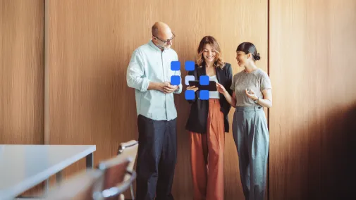 Three people are standing and talking to each other.