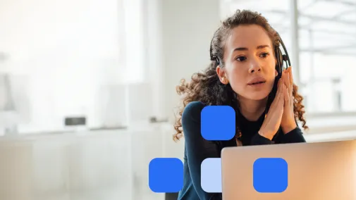 Woman wearing headphones looks intently at her laptop.