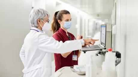 Arzt und Schwester besprechen am Notebook die Planung im Krankenhaus