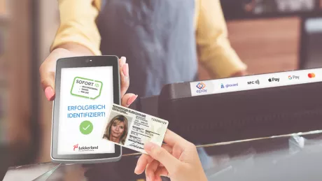 Frau identifiziert sich mit ihrem Ausweis beim bezahlen mit dem Smartphone
