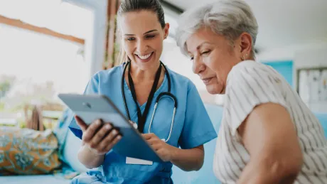Zwei Frauen blicken auf einen Tablet Computer
