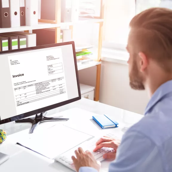 Mann sitzt am Computer im Büro