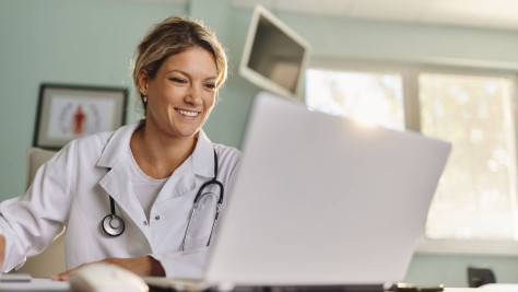 Doctor smiles at laptop