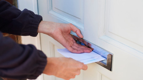 Person puts letter in letterbox