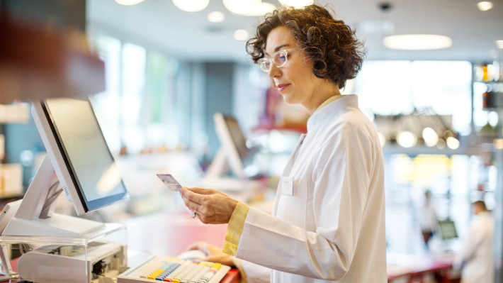 Pharmacist holding a card in her hand